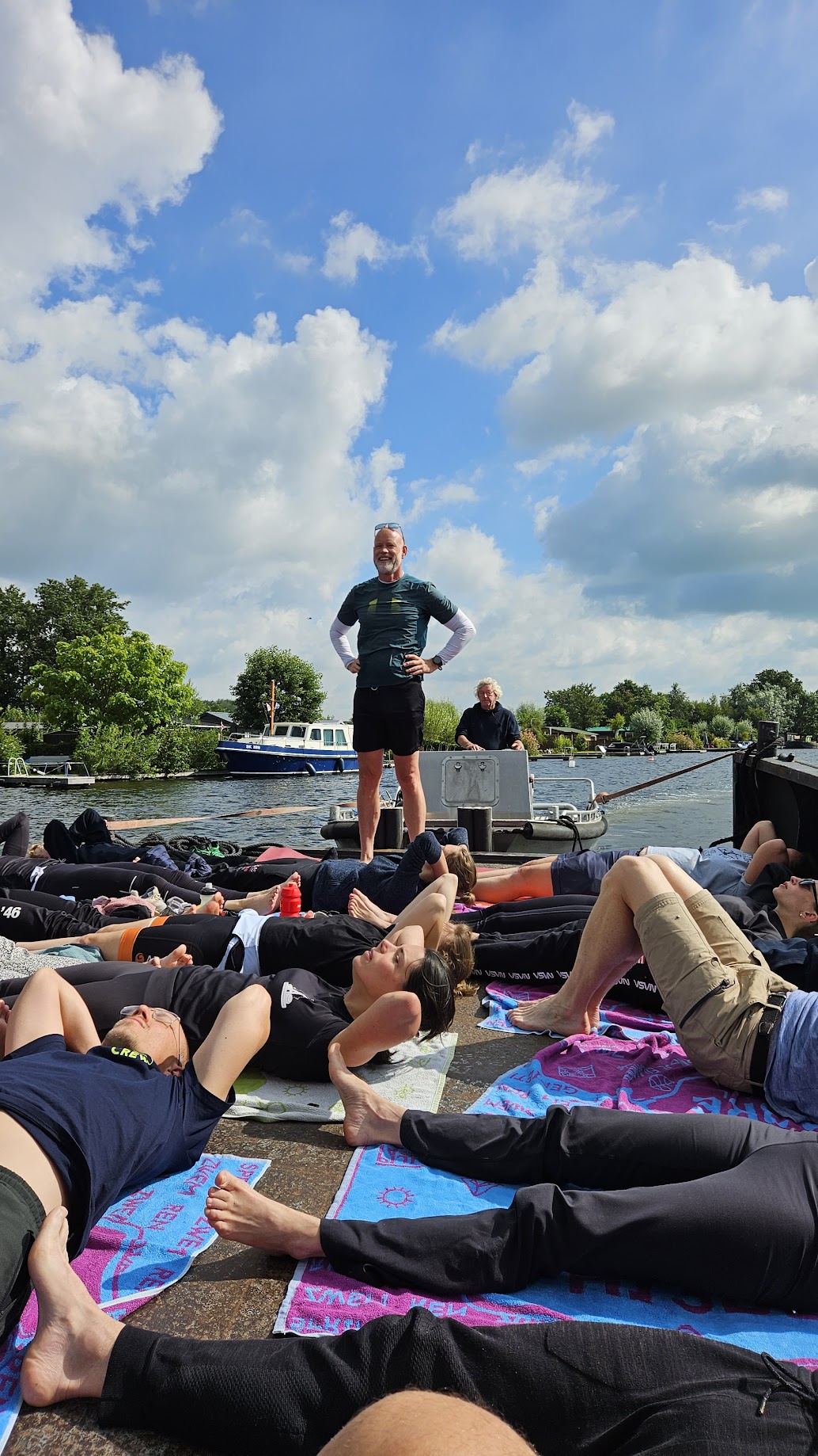 Deelnemers ontspannen op een boot tijdens yoga
